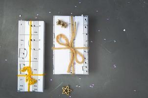 Gifts wrapped in paper with the image of music. Christmas holiday, womens day for the musician.