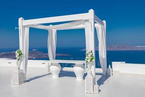 Beautiful wedding tent on Santorini island. Wedding decorations with roses on the background of the sea, Greece, Santorini. Romantic destination wedding, romance concept