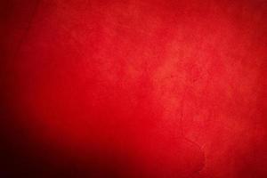 Red suede background. Natural leather macro photo of bright red color with a dark edge.