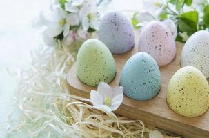 huevos de Pascua en bandeja de madera sobre fondo de madera verde foto