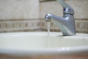 close up of faucet with flowing water photo