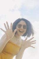 Portrait of happy smiling Asian woman with blue sky view from the bottom. photo