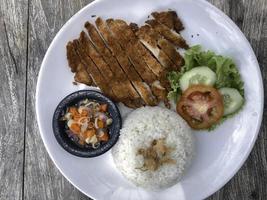 Rice with deep fried chicken and curry in Japanese style or katsu kare in white plate ready to eat. photo