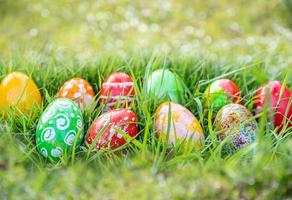 closeup, many beautiful painted easter eggs as grass blurred background. concept for good friday, easter monday, spring full moon. copy space on top for text or design. garden, nobody, selective focus photo