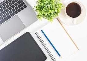 Flat-Lay, Laptop, coffee cup, tablet, and vase on white table in an office. Concept automation office using technology, network, internet. Closeup, top view white background photo