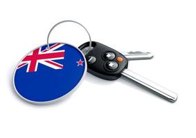 Set of car keys with keyring and country flag. Concept for car prices, buyer or selling a vehicle in New Zealand. Vehicles made and produced in New Zealand. New Zealand vehicle brands. photo