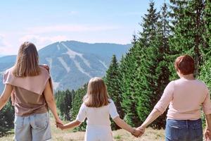 grandmother, mother and daughter travel to the mountains. Nature, travelling environment concept photo