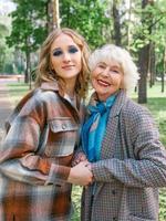 senior woman with young daughter walking outdoor in spring. Family, generation, care, love, vaccination concept photo