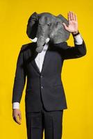 man with an elephant mask on a yellow background photo