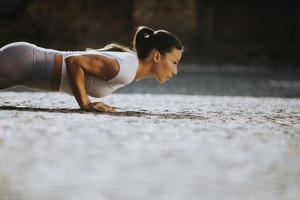 Young woman doing puhsups on the street photo