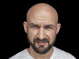 retrato de hombre calvo blanco con barba en camiseta blanca. aislar sobre un fondo negro foto