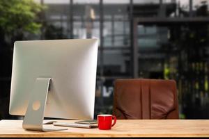Computer Monitor, Keyboard, coffee cup smartphone, tablet, and Mouse with Blank or White Screen Isolated is on the work table in the coffeeshop photo