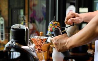 Barista grinding coffee beans for drip brew photo