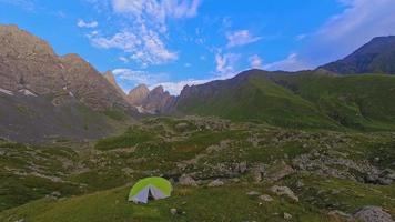 tienda verde de lapso de tiempo en pintorescas montañas verdes tranquilas. caminatas y campamentos en el parque nacional kazbegi por concepto de lagos abudelauri. video