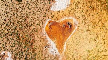 Vue de dessus en forme de coeur orange sur le site des volcans de boue dans la réserve naturelle de chachuna, parc national de vashlovani, géorgie