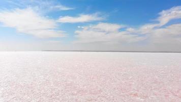 Point of view waking on textured salt lake barefoot in sunny day. Healthy procedures and benefits of salt