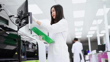 young female scientist working with automation blood analyzer report in medical laboratory video