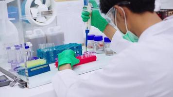 Junger Wissenschaftler mit Pipettentransferprobe in Mikrozentrifugenröhrchen für PCR-Test im Biosicherheitsschrank. video