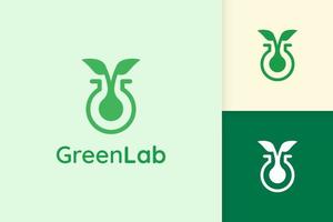 logotipo de laboratorio verde con forma de hoja para ciencia o química vector