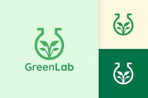 logotipo de laboratorio verde con forma de hoja para ciencia o química vector