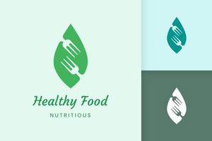 logo de comida saludable con forma de tenedor y hoja vector