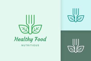 logo de comida saludable con forma de tenedor y hoja vector