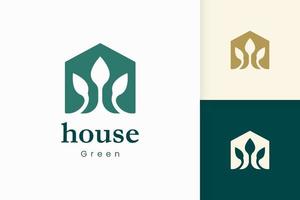 logotipo de la casa verde natural con forma de árbol y hoja vector