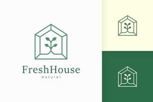 logotipo de la casa verde natural con forma de árbol y hoja vector