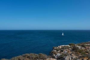 hermoso paisaje marino. día soleado, aguas tranquilas, horizonte y un yate a lo lejos. Portugal foto