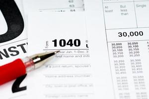 1040 tax form with tax tables and red pen photo