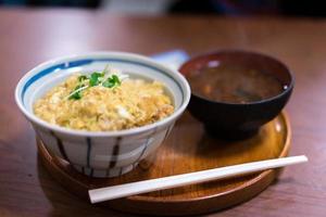 Katsudon served in a large japanese rice bowl with a pair of chopsticks