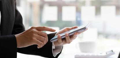 Close up hand of woman using smartphone at office. photo