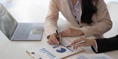 grupo de empresarios reunidos apuntando al gráfico para evaluar los beneficios empresariales. foto