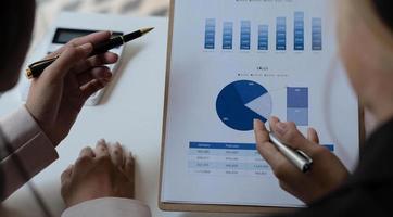 Close up  business people meeting together Pointing to the graph assess business profits. photo