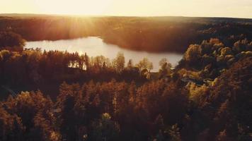 Lago de vista cinematográfica com floresta em cores de outono com pôr do sol no horizonte. queda tranquila no campo.