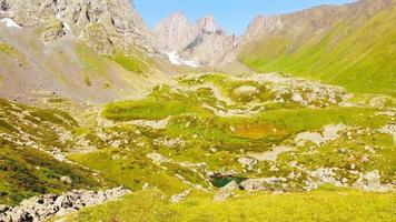 Aerial views scenic green glacier lake with tourist in Kazbegi national park. Georgia travel hiking routes destination. video