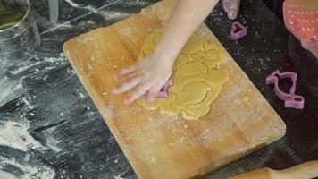petite fille coupant la forme d'étoile d'une pâte pour faire cuire des biscuits de pâques video
