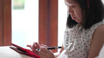 close-up van een vrouw die de stylus gebruikt om thuis op een digitale tablet te schrijven video