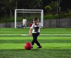 niño pequeño jugando a la pelota foto