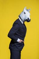 man with horse mask on yellow background photo