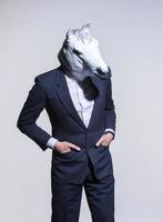 hombre con una máscara de caballo sobre un fondo claro foto