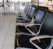 black empty chairs in public area near gate in airport photo