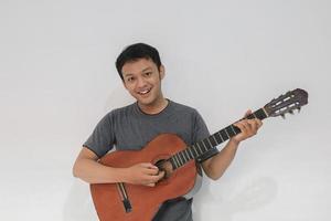 feliz y sonriente joven músico asiático con guitarra foto