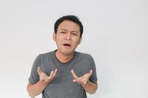 expresión triste y asustada de un joven asiático con camiseta gris foto