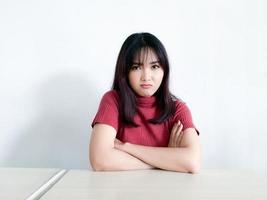 hermosa chica asiática está enojada y enojada con los brazos cruzados aislada en el fondo blanco. foto