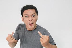 Angry and hate face of young Asian man in gray t-shirt with angry hand gesture photo