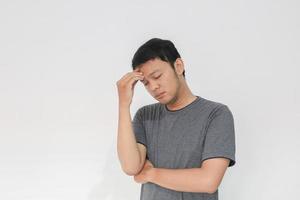 Young Asian man wear grey shirt with thinking and looking idea gesture photo