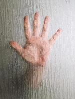 hand behind frosted glass window photo