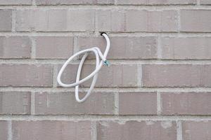 electrical wire or power cable hanging from exterior wall photo