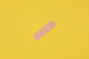 adhesive plaster tape or medical strip on yellow background photo